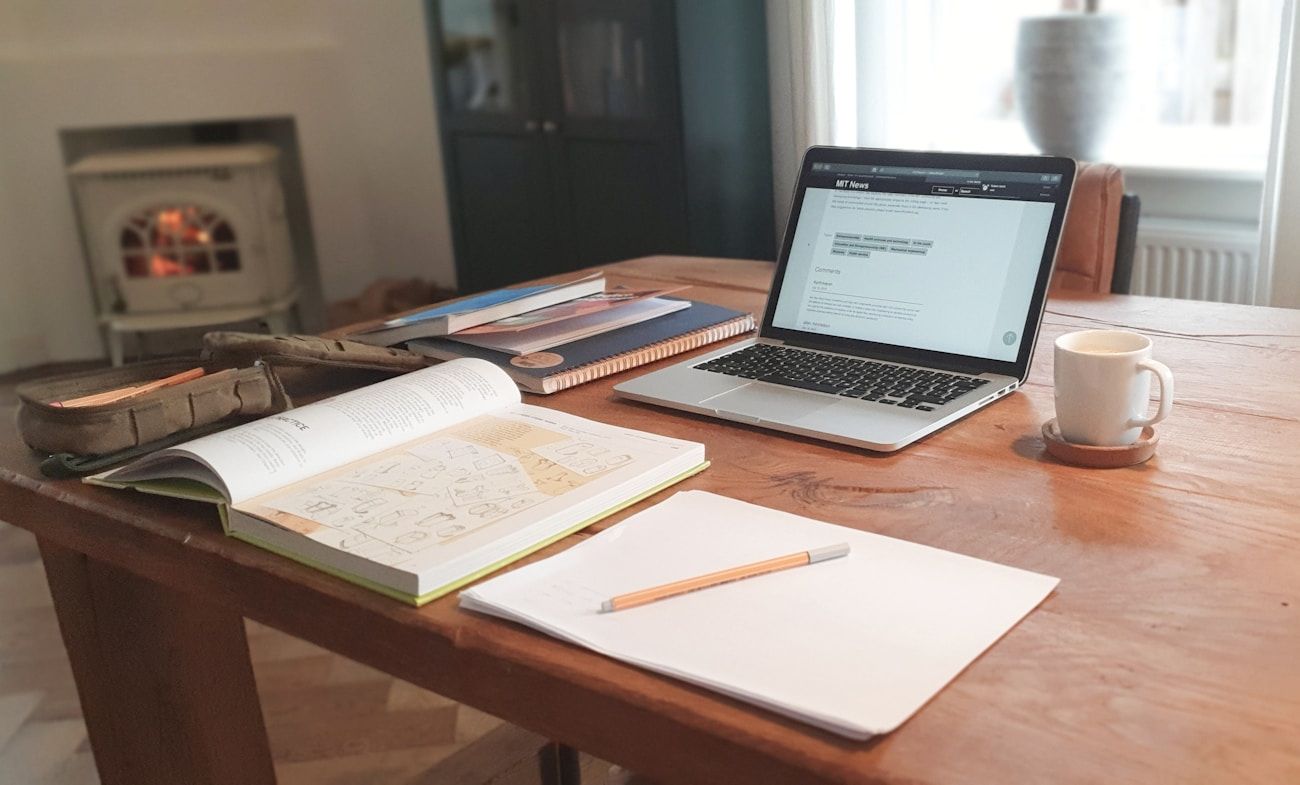 A desk with open notes, a laptop and coffee — the way EHL students actually revise